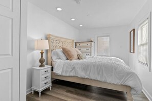A bedroom with a bed, nightstand, dresser, and a lamp. - Warm & Welcoming 5BR Home (South Burlington)