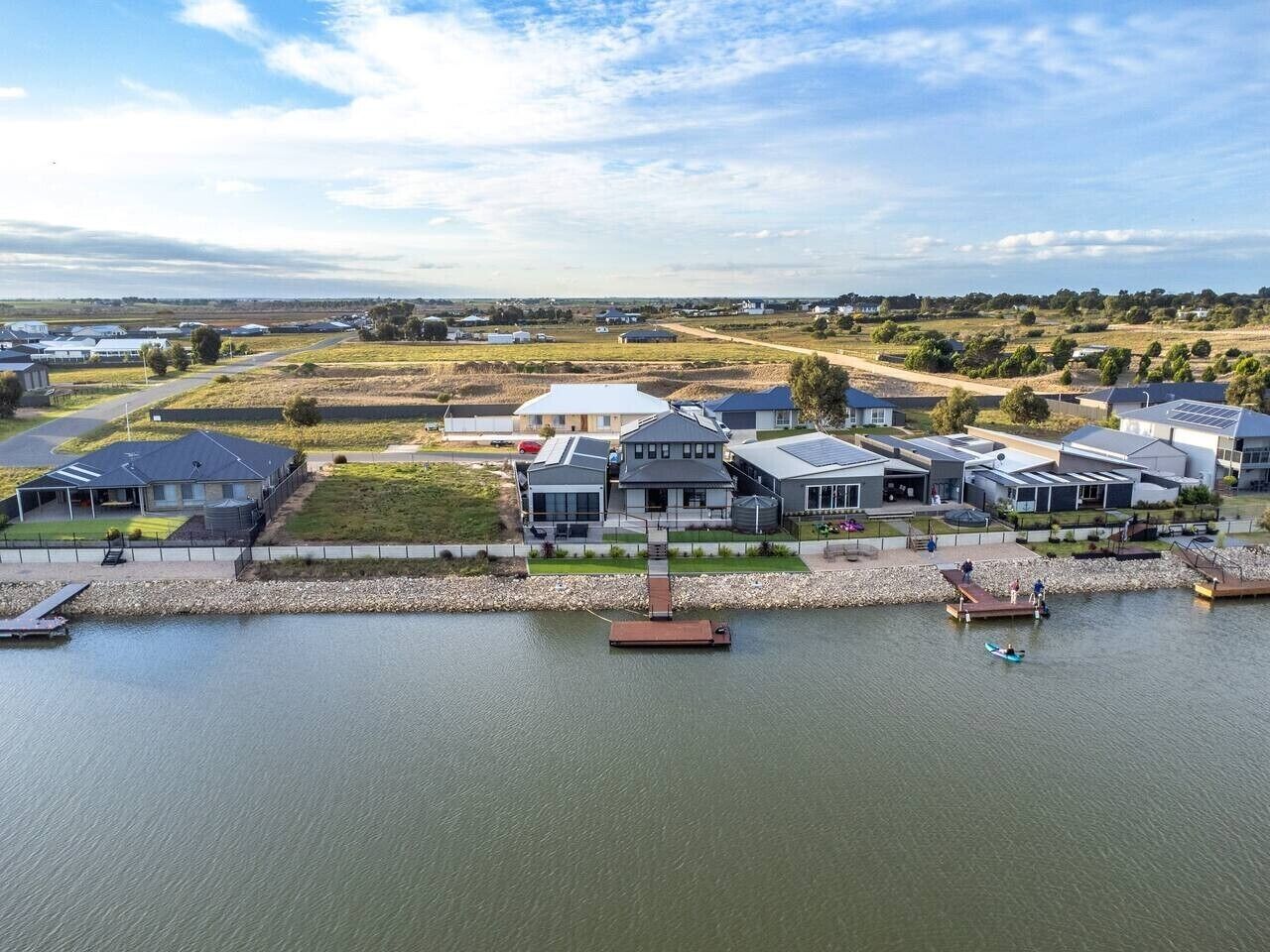 A residential area with houses, a dock, and a body of water.