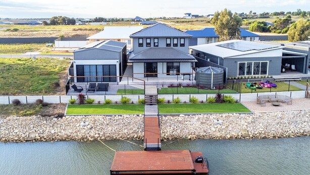 A residential area with modern houses, a dock, and a water body.
