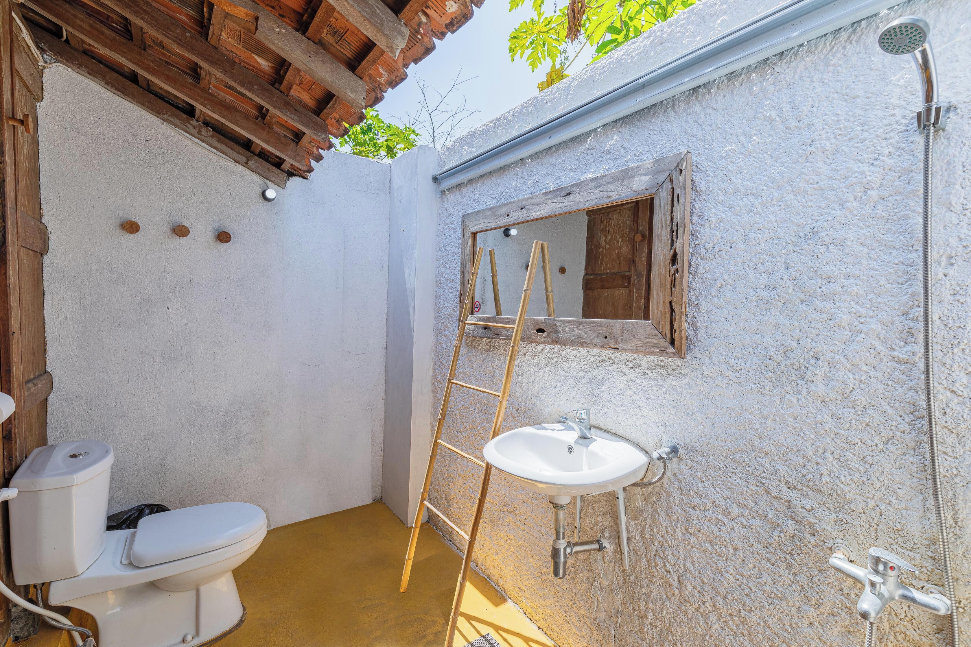A small bathroom with a toilet, sink, and shower.