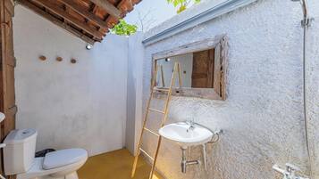 A small bathroom with a toilet, sink, and shower.