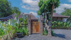 Il s’agit d’un bâtiment traditionnel, doté d’un toit en tuiles, d’une porte en bois et d’un chemin de gravier menant à l’entrée.