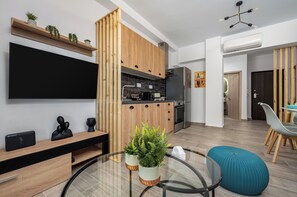 A modern kitchen with wooden cabinets, a black refrigerator, and a built-in oven.