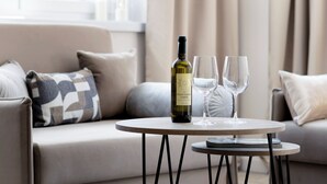 Eine Flasche Pinot Grigio Garda Wein auf einem runden Tisch, dazu zwei Weingläser.