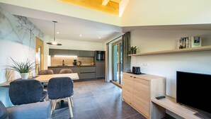 Un ambiente moderno con zona pranzo, cucina e angolo relax.