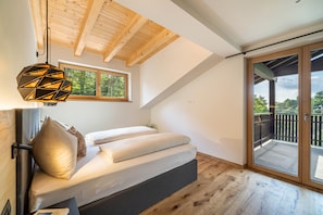 A loft bedroom with a bed, a geometric pendant light, a window, and a balcony. - Apartment "Wiesgut Golden" with Mountain View, Private Terrace and Wi-Fi (Tesimo)