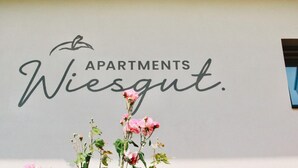 Un muro con il testo 'Apartments Wiesgut' e un'decorazione floreale.