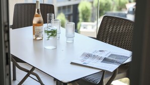 A table with a bottle, glasses, and a newspaper. - 3BR SeaView Apt by the Beach by SeaNRent (Herzliya)
