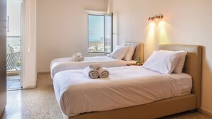 A hotel room with two beds, a balcony, and a view of the city. - 3BR SeaView Apt by the Beach by SeaNRent (Herzliya)