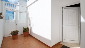 A white exterior wall with a door, two potted plants, and a window. - Vacation Home "Casa Tipica Canaria" with Sea View, Private Terrace & Wi-Fi (Playa Honda)