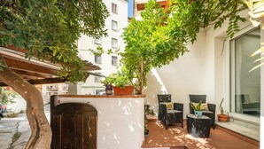 A patio with outdoor seating, a wooden door, and potted plants. - Apartment "In Casetta" with Private Garden and Wi-Fi (Cagliari)