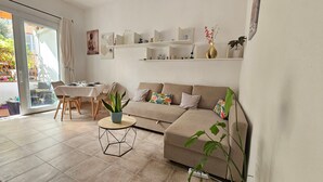 A modern living room with a sofa, coffee table, and dining area. - Apartment "In Casetta" with Private Garden and Wi-Fi (Cagliari)