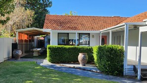 Una casa moderna con techo de tejas, un porche cubierto y un césped cuidado.