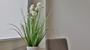 A potted plant with long green leaves and white flowers on a windowsill next to a chair. - Big Family Suite with 7 beds in the center of Göppingen (Göppingen)