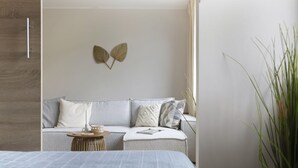 Une chambre à coucher moderne avec un lit, un canapé et une petite table d’appoint.