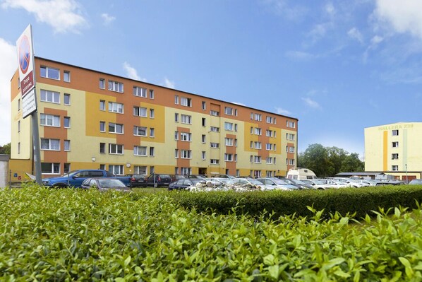 A multi-story hotel with a parking lot in front.