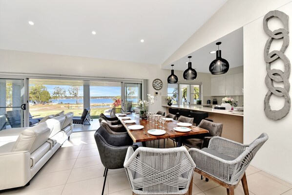 Una cocina moderna con comedor, ventanas amplias y vistas al exterior.