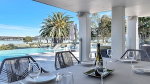 Comedor con vista a una piscina y palmeras.