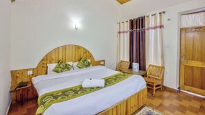 A wooden-framed bedroom with a bed, a chair, and a wardrobe. - Hotel Thakur (Manali)