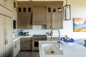 Enjoy cooking in this well-equipped kitchen with a central island, sink, and gas stove.