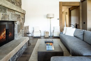 Cozy living room with a fireplace, armchairs, and a sofa.