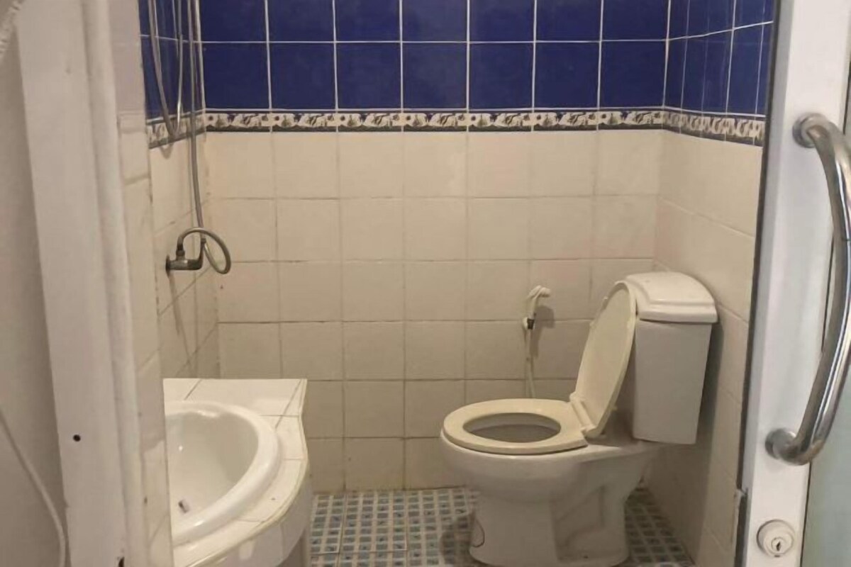 Um banheiro pequeno com vaso sanitário, bidê e chuveiro.