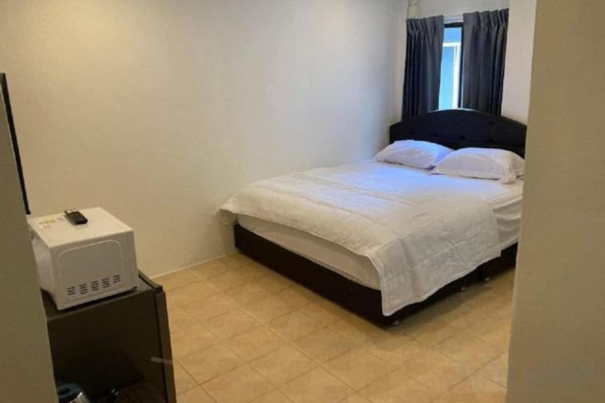 Une chambre à coucher avec un lit, une table de chevet et un radiateur fixé au mur.