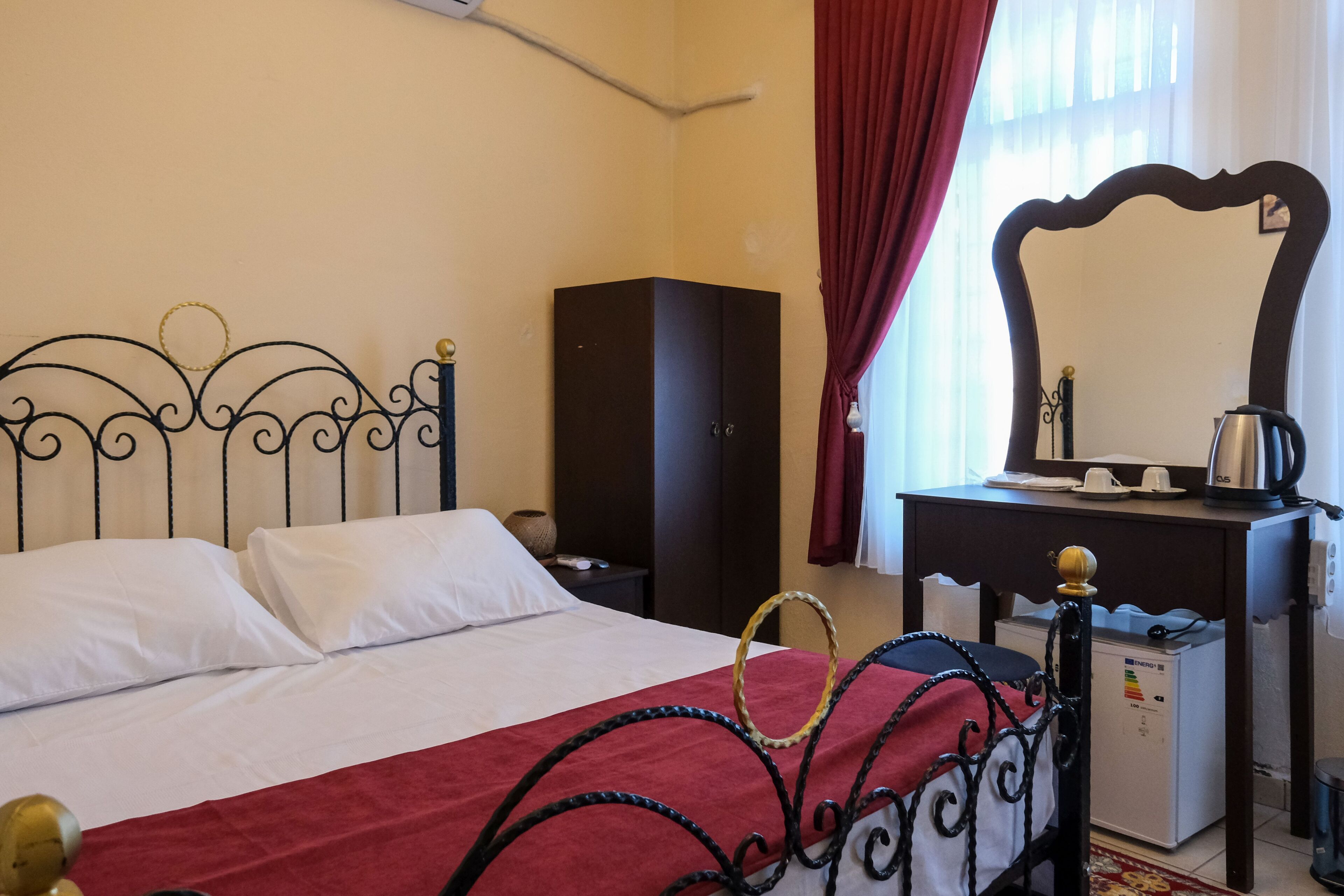 Una habitación de hotel con cama, cómoda, espejo y un mueble pequeño.