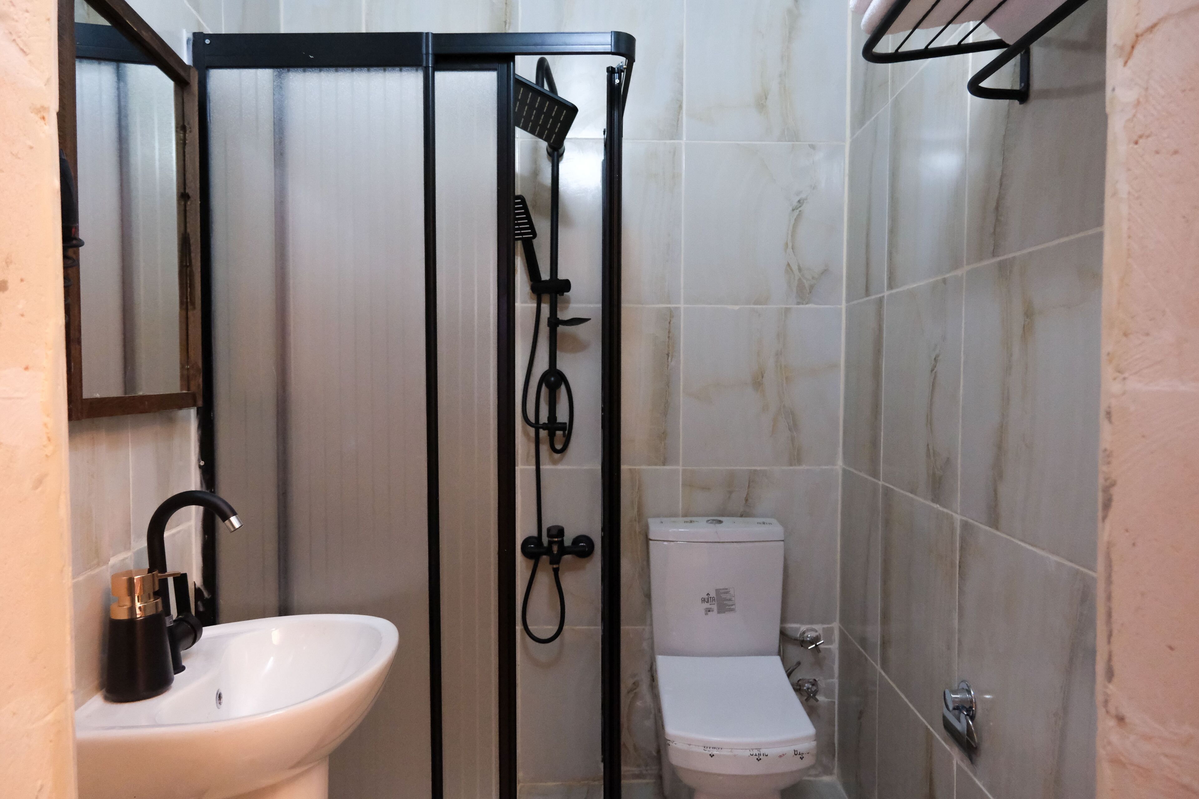 A bathroom with a white sink, a toilet, and a shower enclosure.