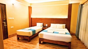 A hotel room with two single beds, a wooden headboard, a nightstand, and a window with curtains. - Hotel Chino Pokhara Pvt. Ltd. (Pokhara)