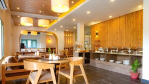 A modern restaurant with wooden furniture, a buffet area, and a seating area with a view. - Hotel Chino Pokhara Pvt. Ltd. (Pokhara)