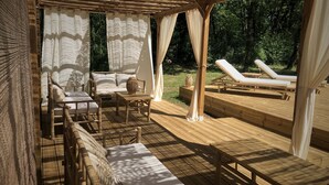 A wooden deck with outdoor furniture, including a sofa, chairs, and a table.