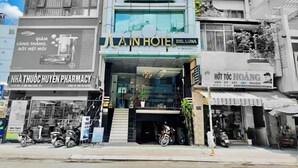 A hotel with a modern facade, a visible entrance, and a sign for a nearby pharmacy. - A IN HOTEL DEL LUNA (Ho Chi Minh City)
