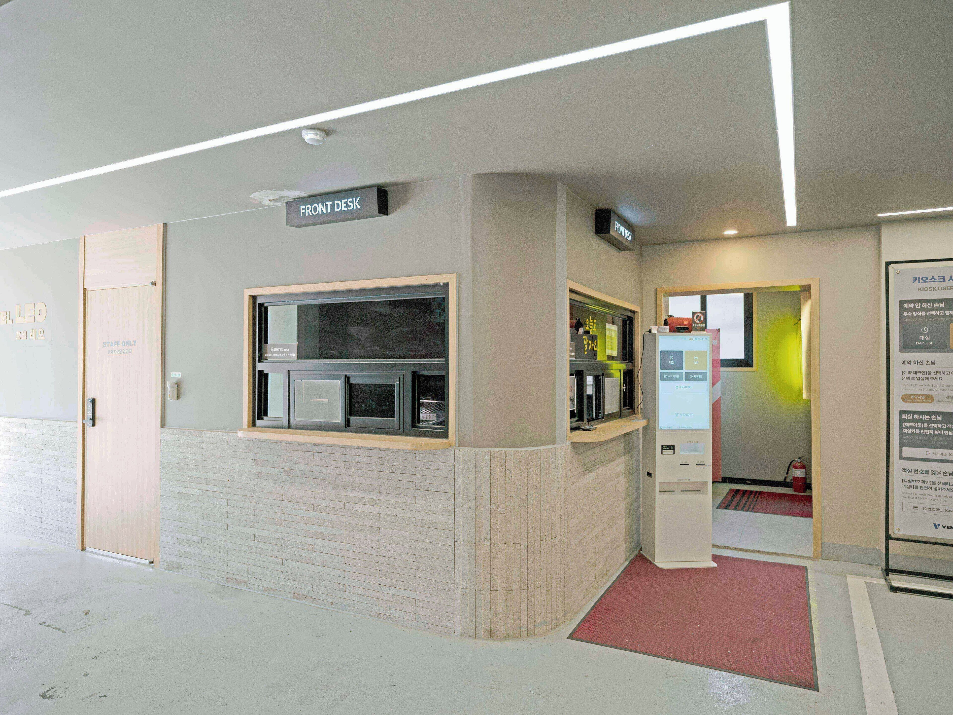 A front desk area with a sign, a vending machine, and a fire extinguisher.