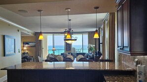 A spacious living area with a large island, dark wood cabinetry, and pendant lighting. - Bella Riva 409 4 bedroom Beachfront (Fort Walton Beach)