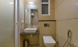 Ein kleines, kompaktes Badezimmer mit einem weißen Waschbecken, einer Toilette und einer Dusche.
