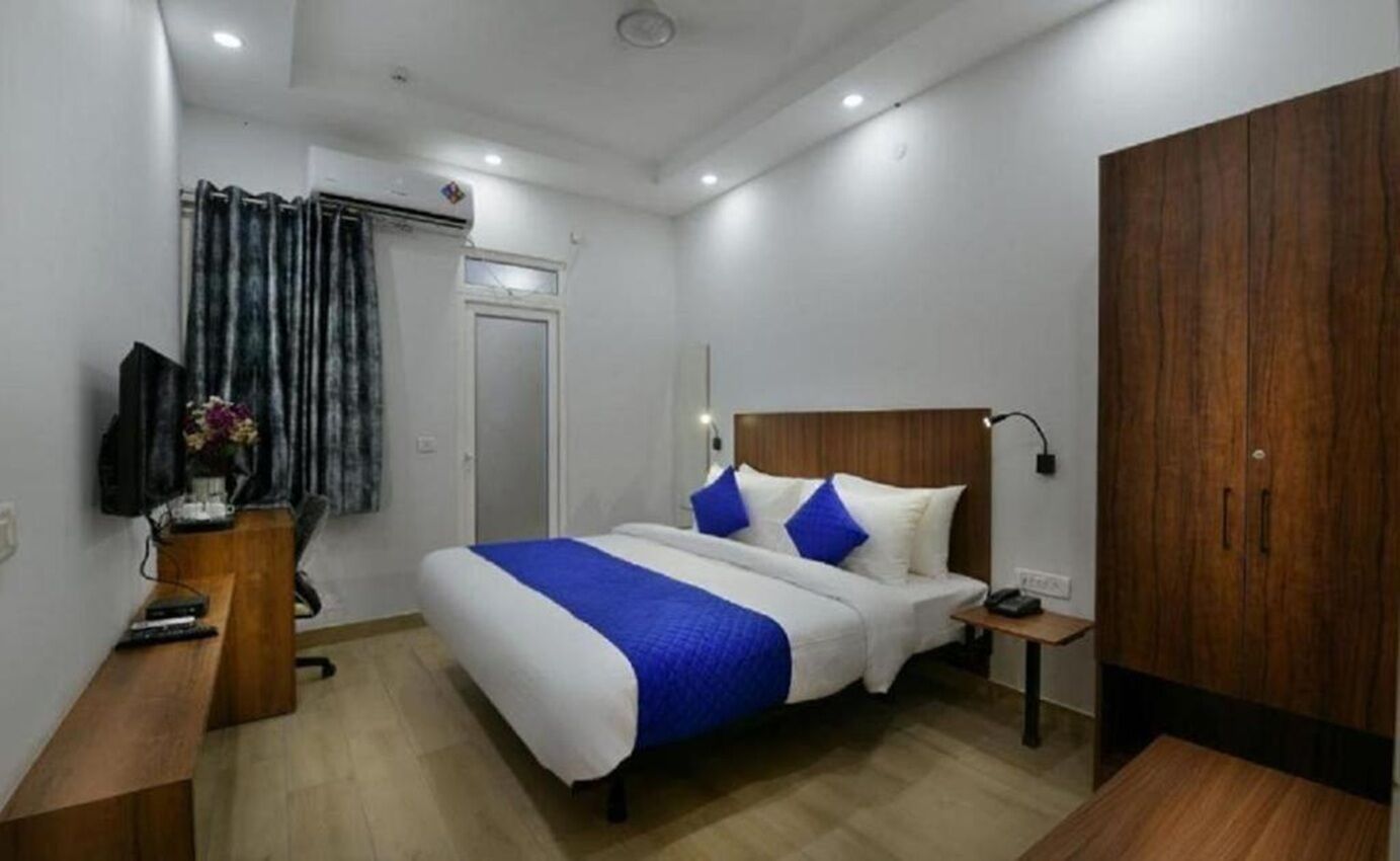 A hotel room with a bed, bedside table, and a wardrobe.