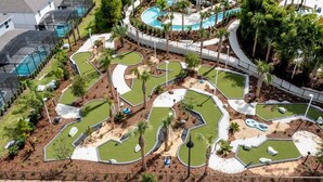 Ein Golfplatz mit mehreren Putting-Greens, einem Poolbereich und umliegender Bepflanzung.