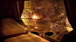 A cozy room with a bed, a small table, and chairs, overlooking a fire and greenery through a large window. - besshoonsen midoriya (Ueda)