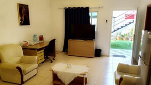 A living room with a sofa, a coffee table, a TV, and a dresser. - Natalia Guest House (Luanda)