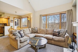 Room for Everyone to Unwind - The open living area offers plenty of comfortable seating and beautiful woodland views through oversized windows. - One Bedroom, Full Vacation Mode J5B (Killington)
