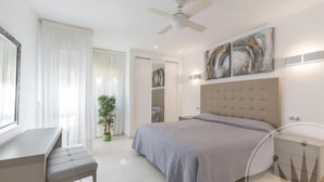 A modern bedroom with a large bed, a desk, and a ceiling fan. - La Manga Club Los Olivos Apartment 600 (Atamaría)