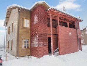 Un edificio de dos pisos con fachada de madera y exterior rojo.