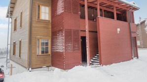 A two-story building with a wooden facade and a red exterior.