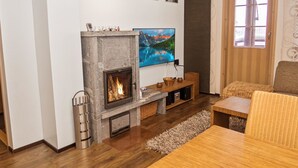 A living room with a fireplace, a television mounted on the wall, and a sofa.