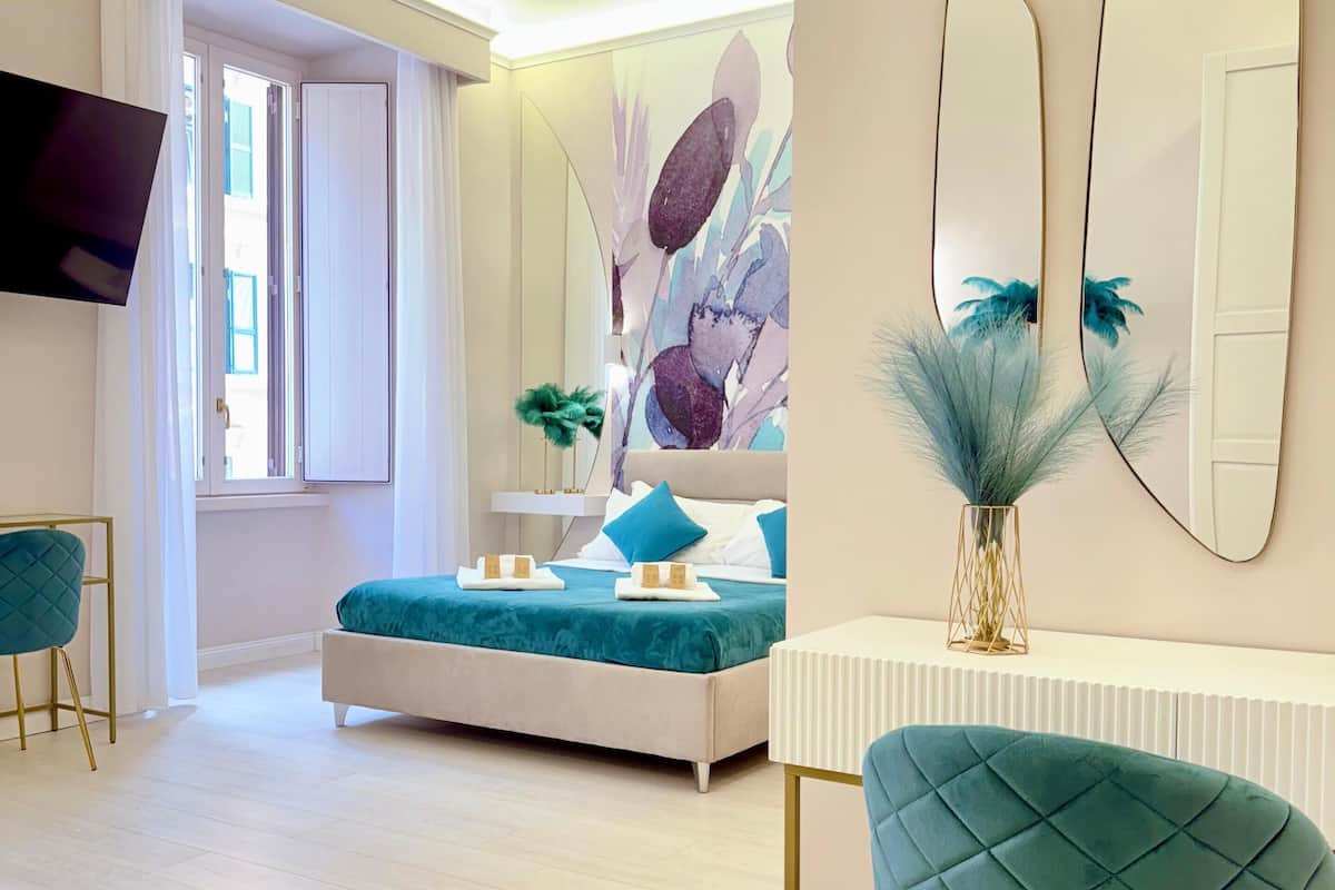 Ein modernes Hotelzimmer mit Bett, Schreibtisch, Stuhl und Fernseher.