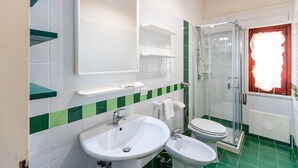 Une salle de bain avec deux lavabos, des toilettes, une douche et un miroir.
