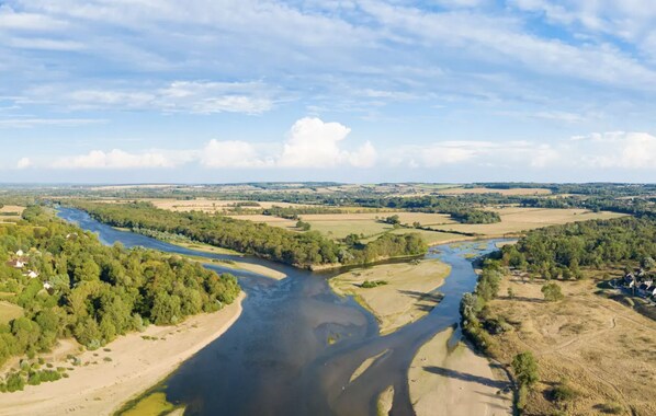 A river meandering through a landscape with fields and sparse trees. - Château de Meauce (Saincaize-Meauce)