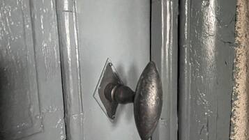 Una puerta con un pomo metálico redondo y una placa cuadrada.