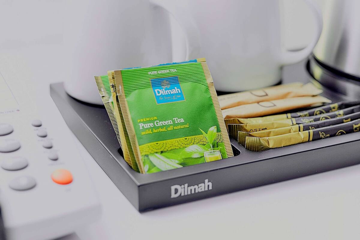 A tray with tea packets and a remote control.
